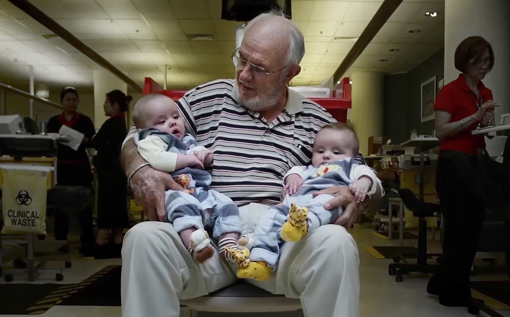 דמו מכיל נוגדנים נדירים מאוד, שאפשר להפיק מהם חיסון למחלת היילוד. ג'יימס הריסון עם שני תינוקות שאימם קיבלה את החיסון מדמו | ויקימדיה, Michelle de Beer