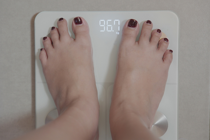 השמנת יתר הפכה נפוצה יותר עם השנים, ומשפיעה על מיליוני אנשים. אישה עומדת על משקל | Shutterstock, Teguh Pamujiono