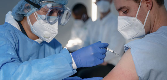 אדם מקבל חיסון קורונה | צילום: Mongkolchon Akesin, Shutterstock