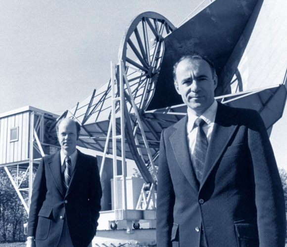 כמו זוג יונים. וילסון (מאחור) ופנזיאס על רקע האנטנה שגילתה את קרינת הרקע הקוסמית | מקור: Science Photo Library