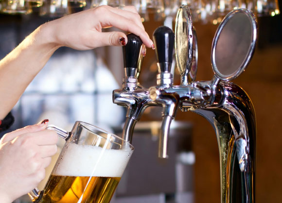 אישה מוזגת בירה לכוס