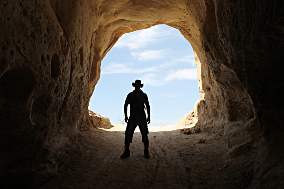An archaeologist at the entrance of a cave near Horvat Midras