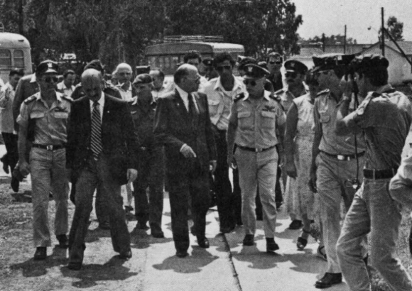 ראש הממשלה מנחם בגין (במרכז) מבקר בבסיס חיל האוויר לאחר הפצצת הכור העיראקי. לידו (חובש כובע) מפקד חיל האוויר, דוד עברי, לימים אחד המקדמים הבולטים של תוכנית הלוויין | צילום: דובר צה"ל, ויקיפדיה