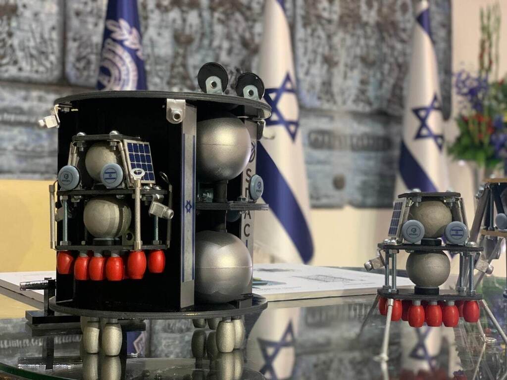 תכנון ראשוני. דגם של בראשית-2 שהוצג בטקס בבית הנשיא. משמאל: הלוויין ובתוכו אחת הנחתות, מימין: הנחתת בחוץ עם רגלי נחיתה פתוחות