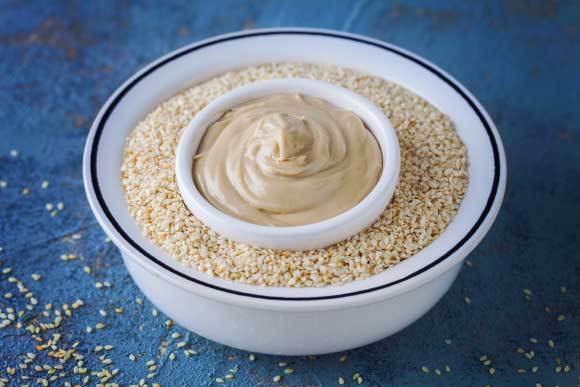 מטבל טחינה מוכן על מצע של זרעי שומשום | matka_Wariatka, Shutterstock