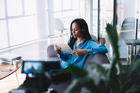 אישה קוראת ומקשיבה למוזיקה באוזניות | Shutterstock, GaudiLab