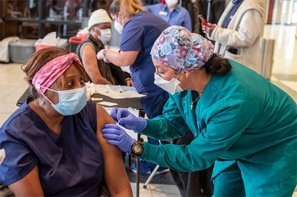 אשה בהכנות לקבלת החיסון | צילום: JIM WEST / SCIENCE PHOTO LIBRARY