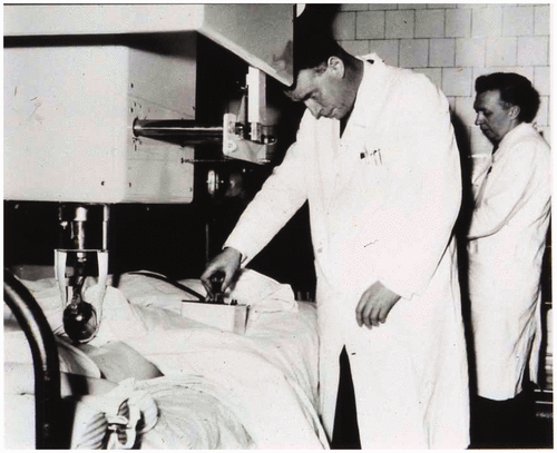 דונלד (בחזית) סורק את בטנה של אישה באולטרסאונד הדו-ממדי, מאחור עומד מקוויקר | צילום מתוך המאמר, שם פורסם באדיבות האיגוד הבריטי לאולטרסאונד רפואי, ברישיון CC BY-NC