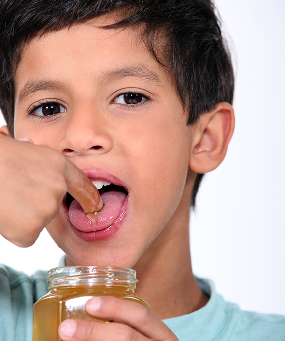 ילד טועם דבש | צילום: Phovoir, Shutterstock