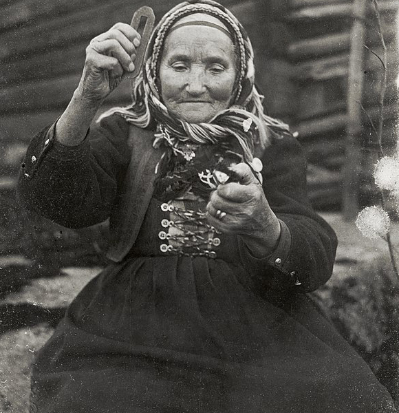 אישה שוודית מקישה כלי פלדה באבן צור כדי להדליק אש, 1916 | ויקיפדיה, Nils Keyland