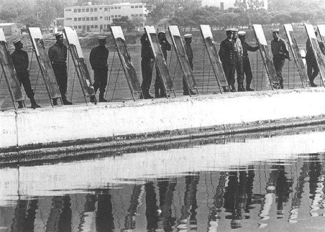 מלחים יוונים מעלים באש דגם של ספינה רומית ממרחק של 50 מטר, באמצעות לוחות נחושת ממורקים המחזירים את אור השמש | מתוך ניסוי של ד"ר יואניס סאקאס היווני, 1973