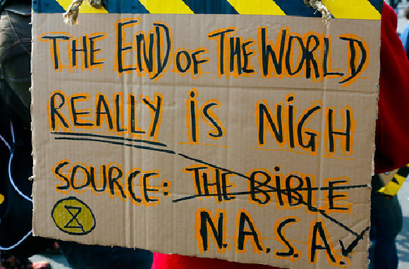 שלט של פעילי "המרד בהכחדה" מזהיר שסוף העולם קרב | צילום: Victor De Schwanberg / Science Photo Library