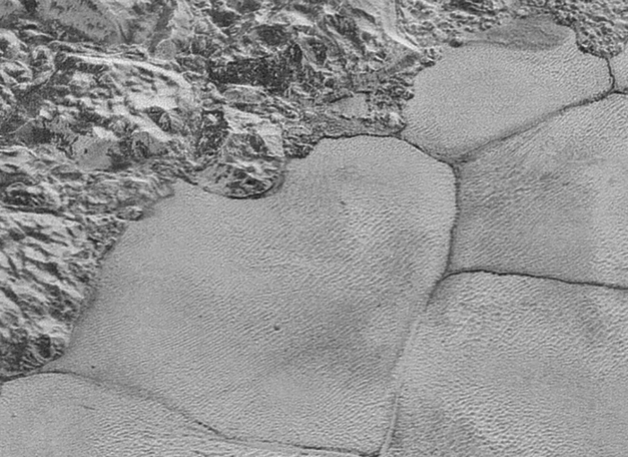 רכסי הדיונות נראים כמו גלים. מישור ספוטניק (מימין) לרגלי רכס ההרים בצילום של New Horizons | מקור: JPL/NASA