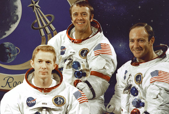 הצוות הכי פחות מנוסה בטיסות חלל. מיטשל (מימין) שפרד (במרכז) ורוסה על רקע סמל המשימה | צילום: נאס"א