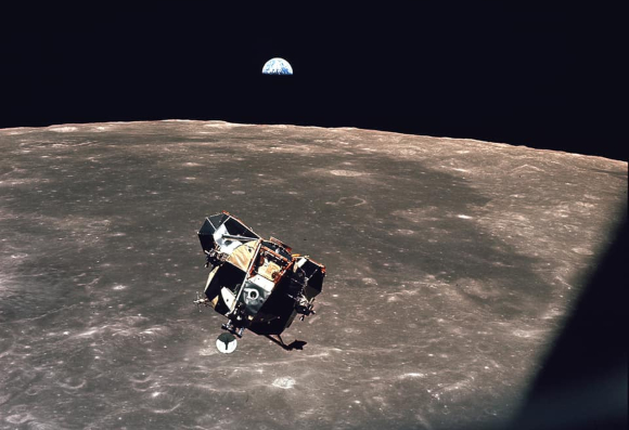 בתמונה המופרסמת שצילם קולינס כלולים כל בני האדם, חוץ ממנו. ארמסטרונג ואולדרין עושים דרכם אליו מפני הירח ב"עיט", וברקע כדור הארץ | צילום: NASA