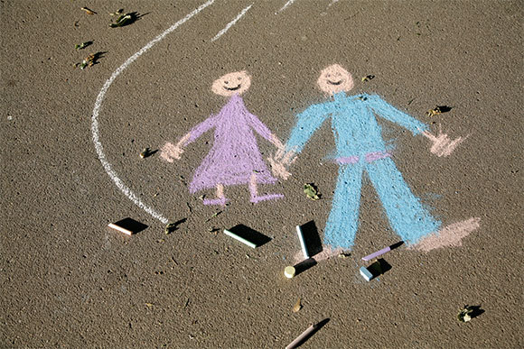 ציור דמויות ילדים בגיר ורוד וכחול | צילום: Anna Jurkovska, Shutterstock