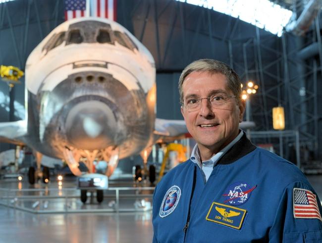 האסטרונאוט דון תומאס על רקע המעבורת דיסקברי | מקור: nssofnt