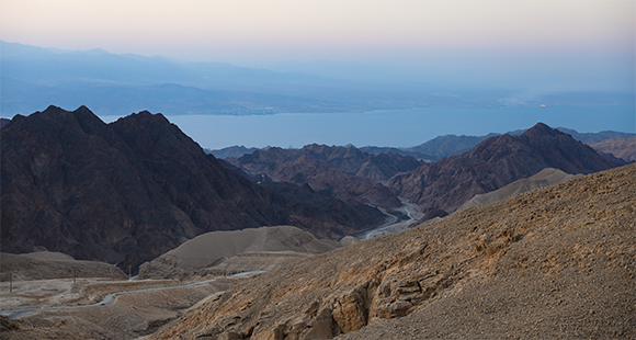 הרים מסיביים ומחודדים בעלי גוון אדמדמם. מבט אל הזריחה בהר שלמה, מעל מפרץ אילת | צילום: rontav, Shutterstock