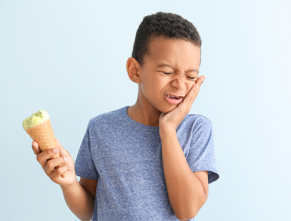  ילד מרגיש כאב שיניים בעת אכילת גלידה | צילום:  Pixel-Shot, Shutterstock