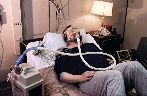 Ein Mann, der unter obstruktivem Atemstillstand leidet, ist bei einem Versuch an das Gerät angeschlossen | Foto: PETER MENZEL / SCIENCE PHOTO LIBRARY