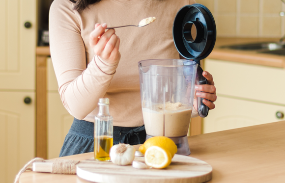 אישה מכינה חומוס חלק בבלנדר | Shutterstock, Andrei David Stock