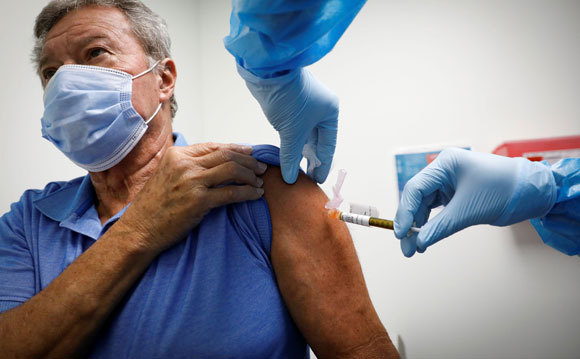 האם אפשר לשלב בין סוגי החיסונים? אזרח בריטי מקבל חיסון בלונדון | צילום: vasilis asvestas, Shutterstock