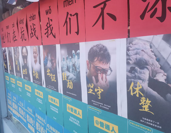 כרזות בסין משבחות את הצוותים הרפואיים וקוראות לאזרחים להישמע להוראות | צילום: kavastudio, Shutterstock