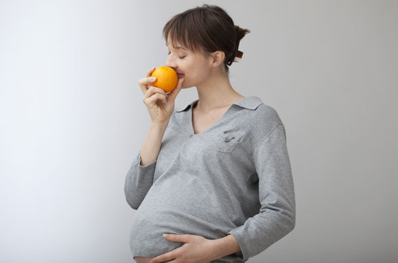 נראה כי השינויים בחוש הטעם נועדו להגן על האישה ההרה ממאכלים מקולקלים. אשה הרה מריחה פרי | צילום: Shutterstock