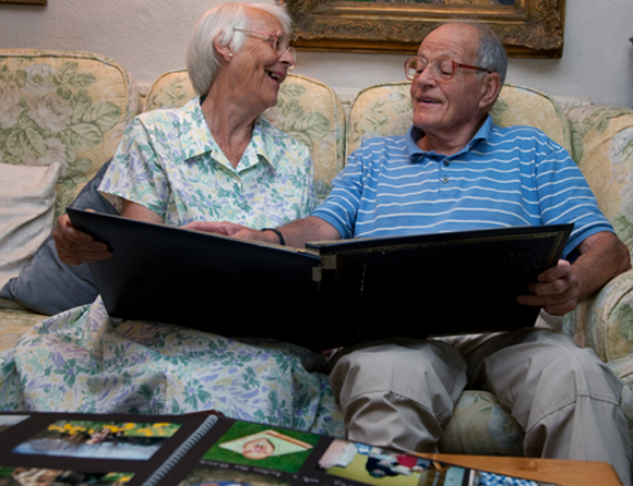 זוג מבוגר מסתכל באלבום תמונות | Science Photo Library