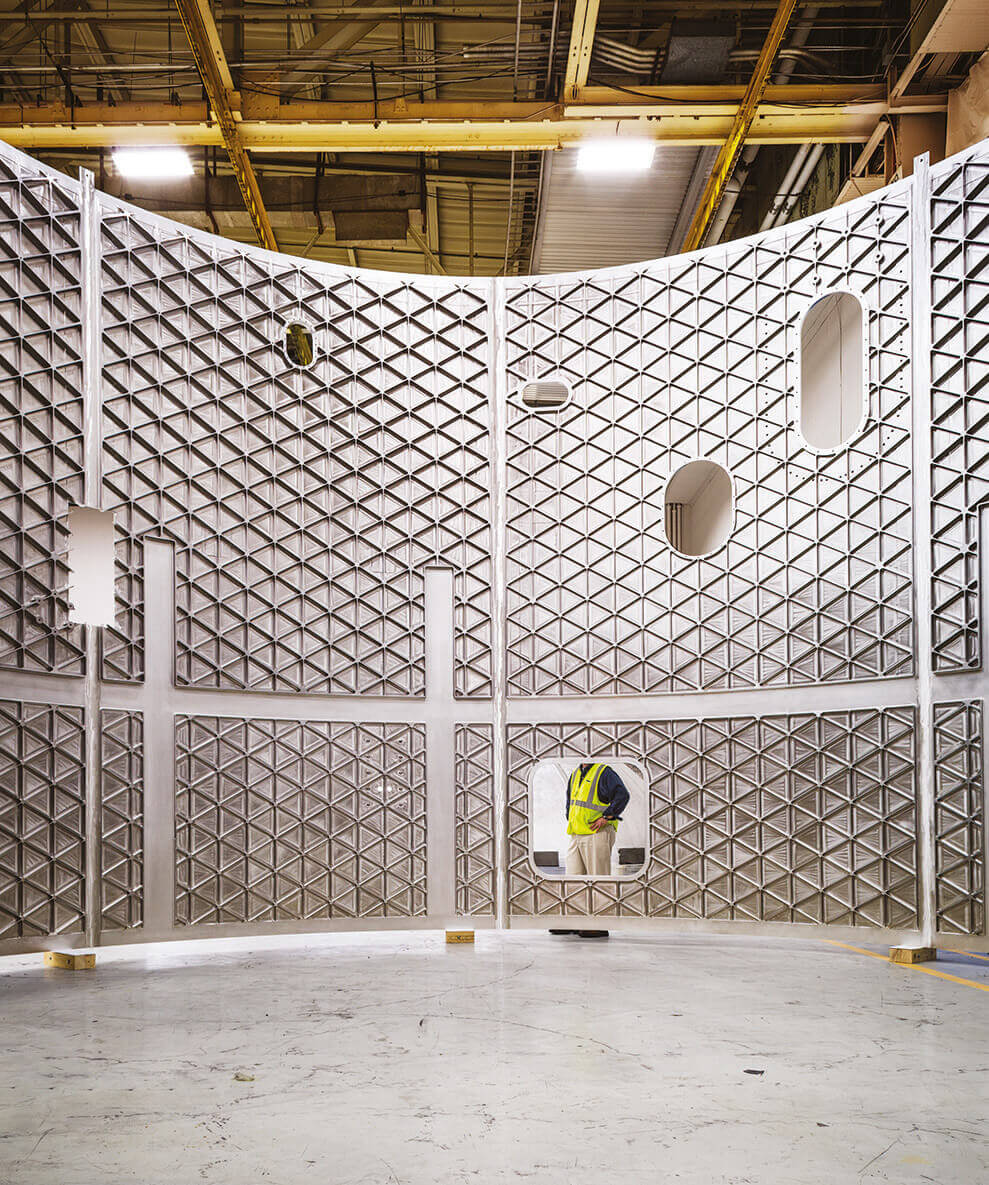 מקטעים מעוגלים מוערמים זה על זה ומרותכים יחדיו כדי ליצור גליל גבוה, שישמש מעטה לשלב הליבה של SLS. בתוך מעטה זה יהיו שני מכלים שיישאו את הדלק לטיל, אחד של מימן נוזלי ואחד של חמצן נוזלי. במתקן ההרכבה מישוּ של נאס"א, מהנדסים בונים כעת גלילי "ביטחון" שמטרתם לבדוק את חוזק החלקים. | Scientific American