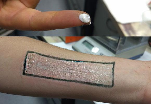 אצבע עם קרם וזרוע מרוחה בקרם