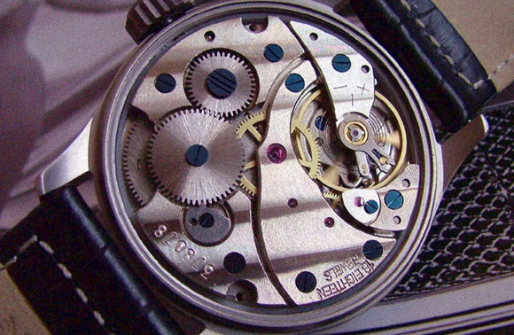 מערכת מורכבת של קפיץ, גלגלי שיניים ומחגר המאפשר להם לנוע בכיוון אחד. שעון מכני | מקור: ויקידפדיה